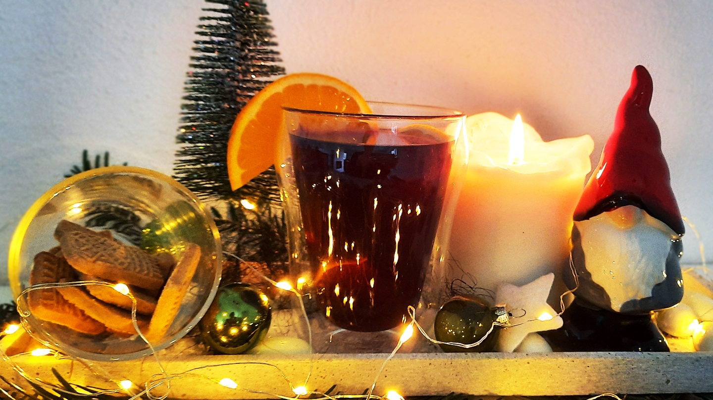 Ein Glas Kinderpunsch mit weihnachtlicher Dekoration.