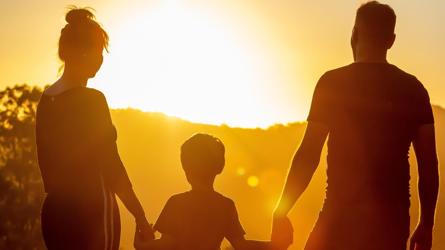 Familie betrachtet Sonnenaufgang