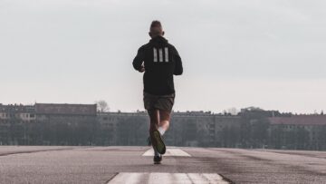 Mann beim Joggen auf einer Teerstraße in einer Stadt.